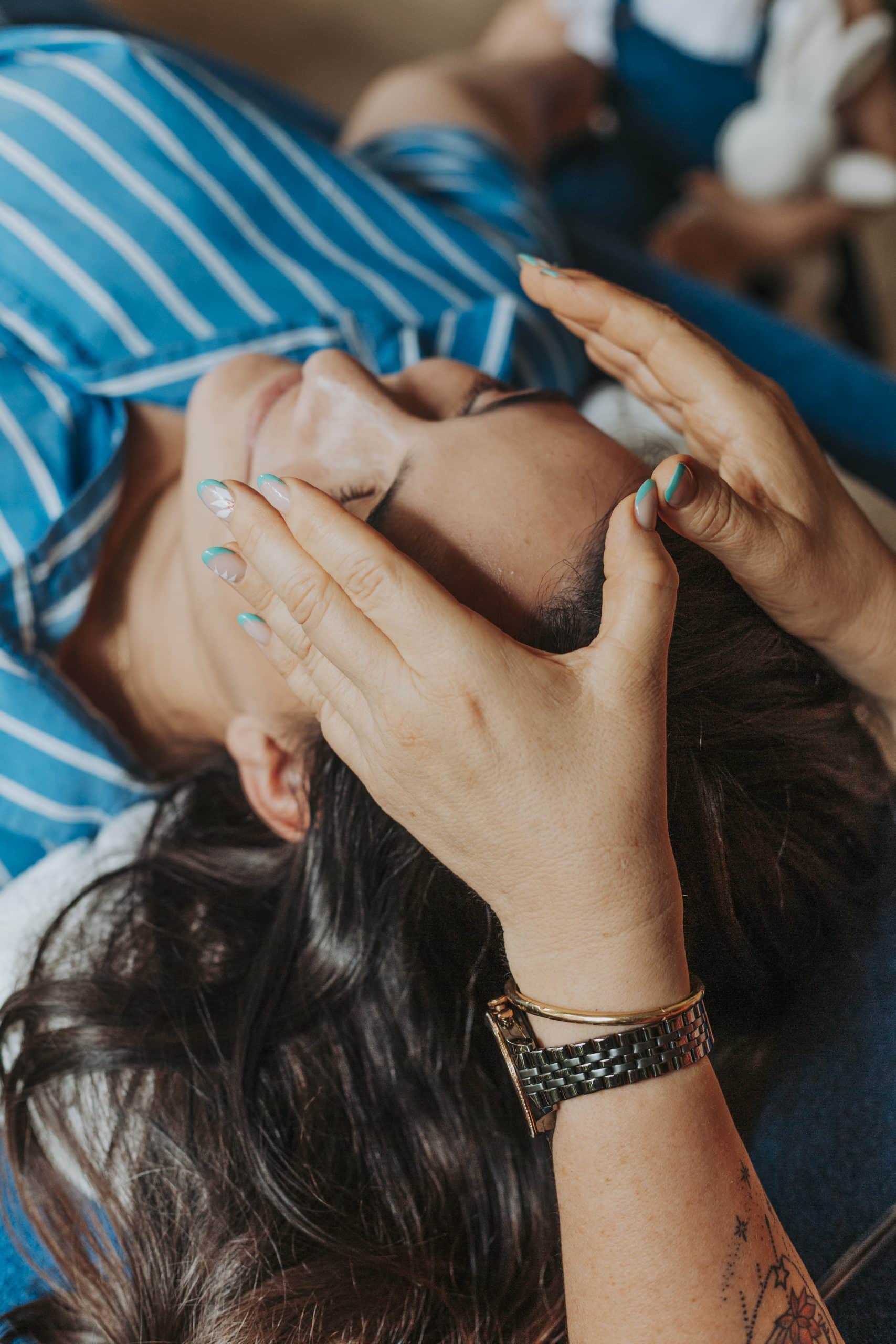Photo de deux mains qui massent les jampbes d'une jeune femme